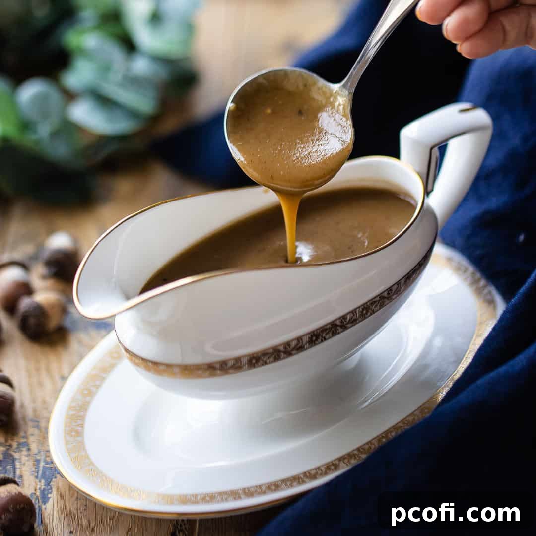 Rich brown gravy being ladled from a delicate bone china gravy boat, showcasing its silky texture.