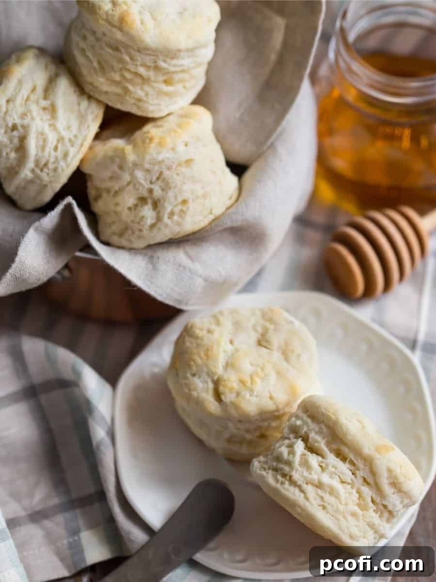 Southern-style biscuits served on white plates, drizzled with golden honey.