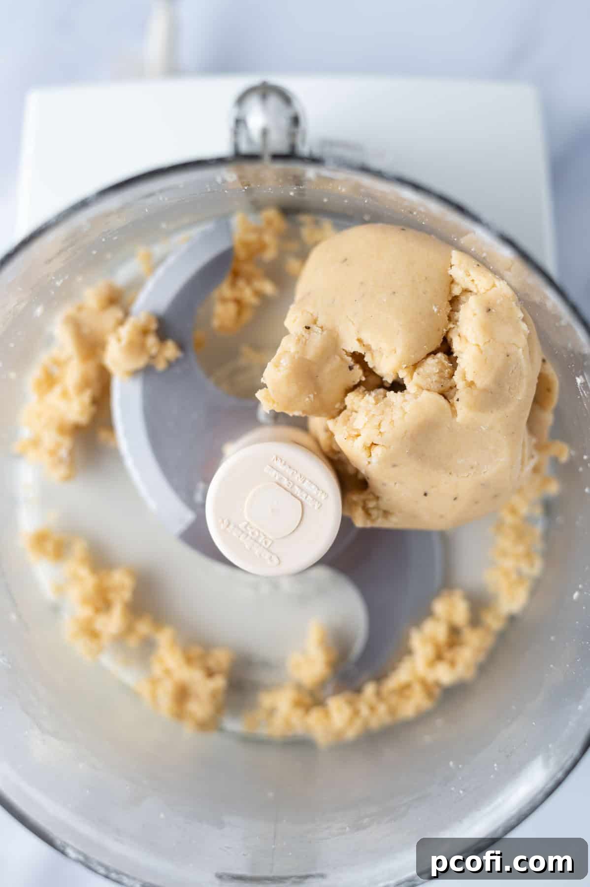 pastry dough balled together in the bowl of a food processor