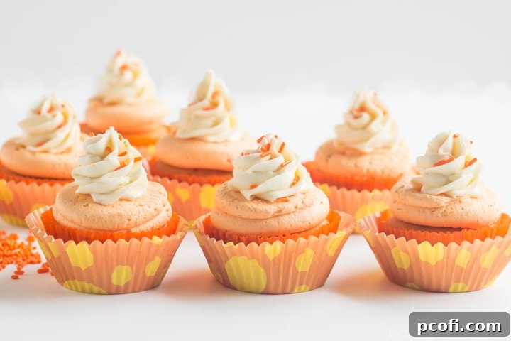 A simple, yet inviting image of a single Orange Creamsicle Cupcake with sprinkles.