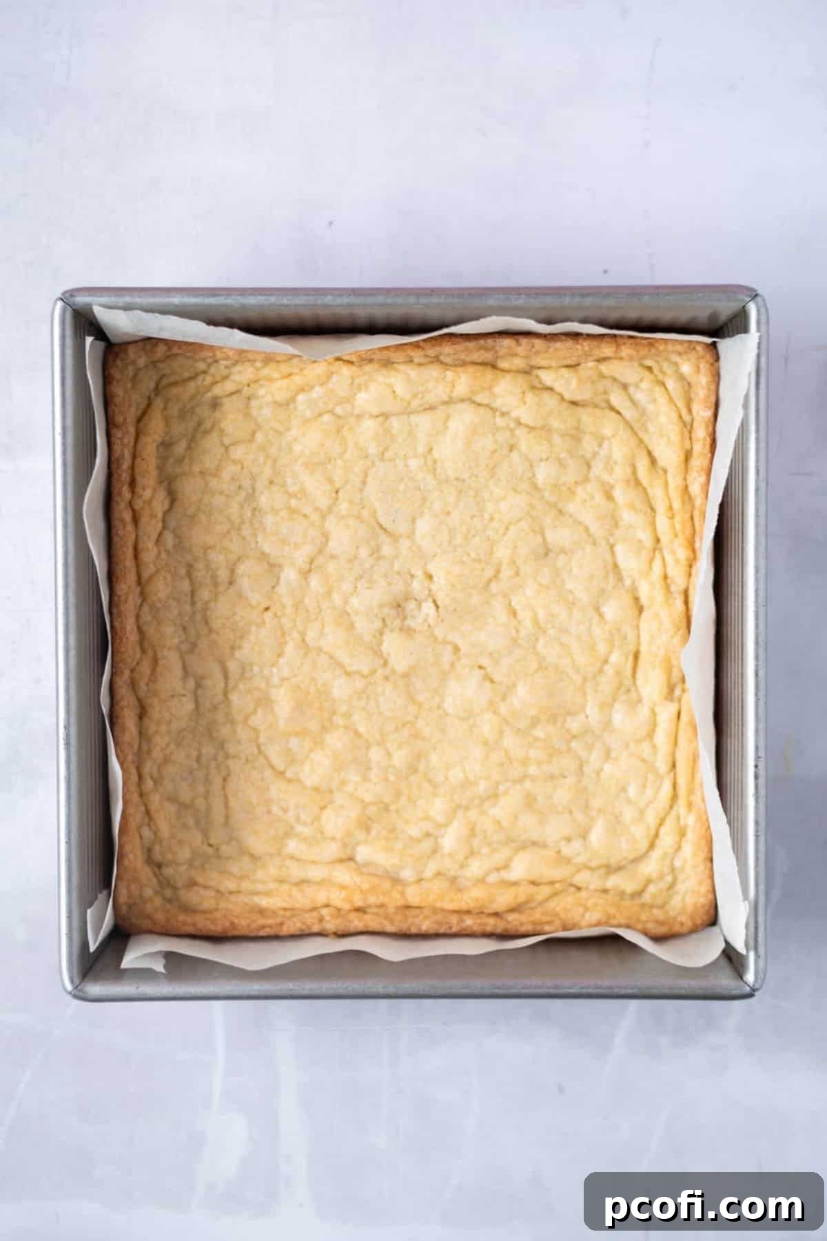 Golden-brown, baked shortbread crust for millionaire's shortbread, cooled in a baking pan.