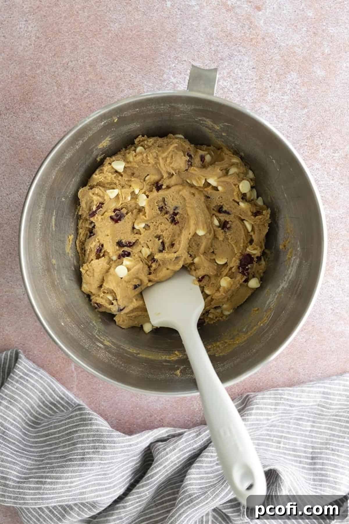 Dried cranberries and white chocolate chips folded into the blondie dough, creating a vibrant and rich mixture.
