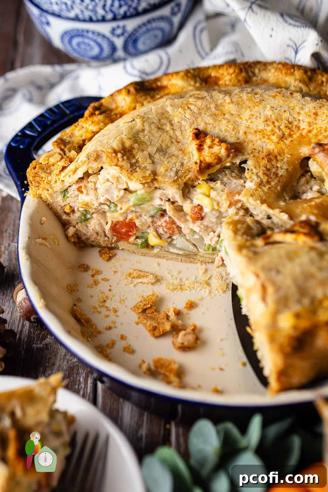 Sliced turkey pot pie revealing its creamy filling and golden crust in a pie dish, ready to be served.