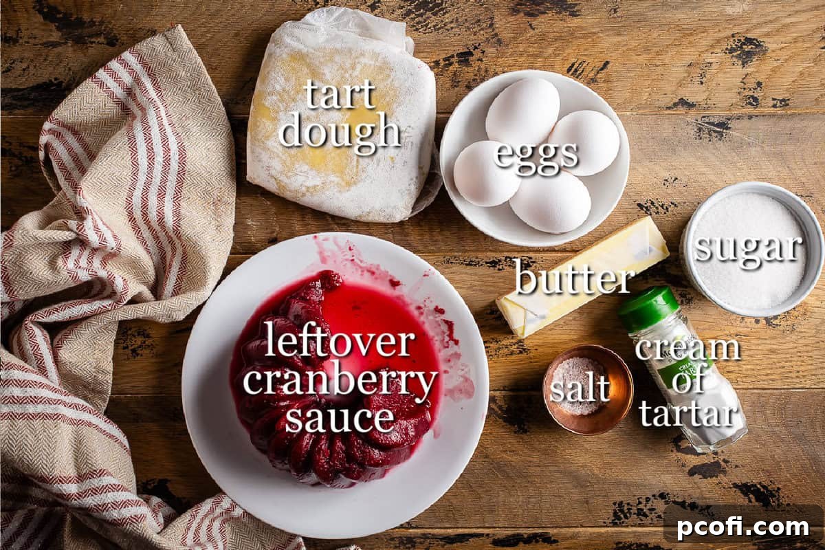 Collection of key ingredients for a cranberry curd tart, including eggs, butter, sugar, and cranberries, arranged artfully.
