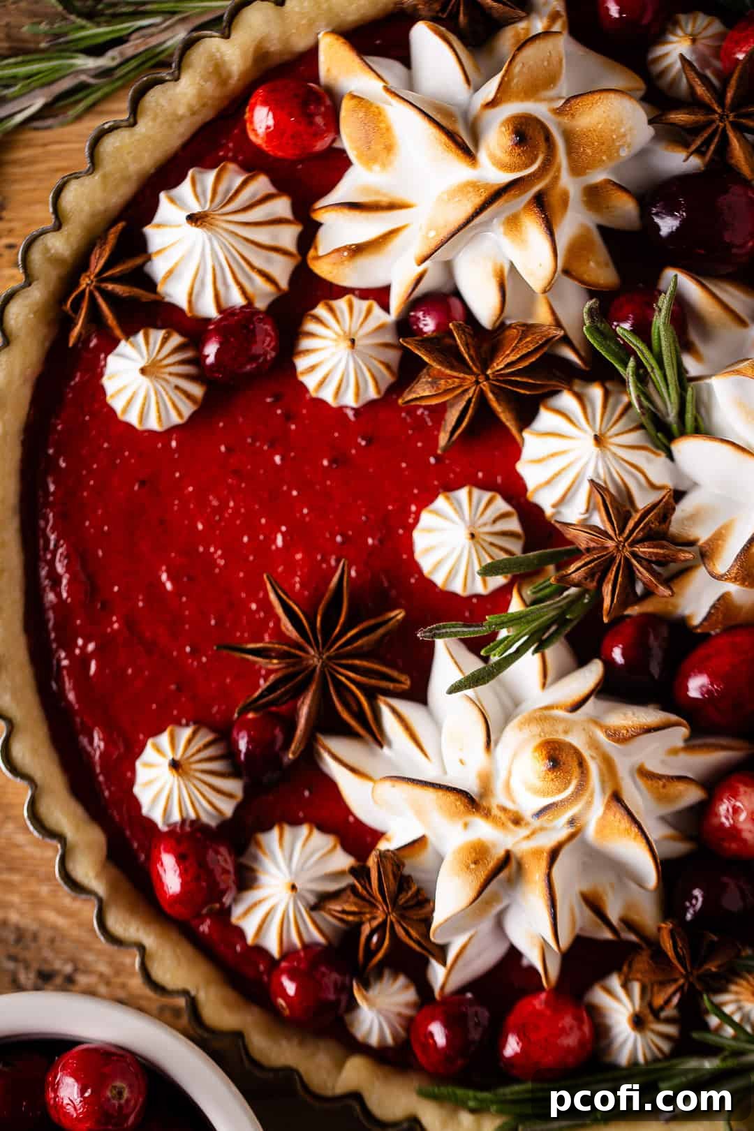 A stunning cranberry curd tart, beautifully topped with swirled meringue, glistening and ready for serving.