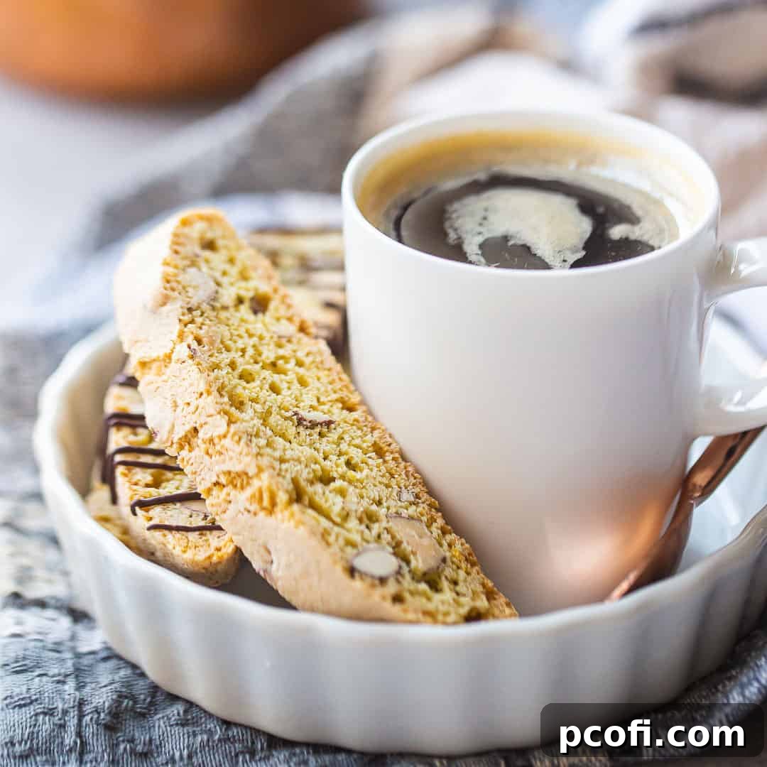 Crunchy almond biscotti cookies, elegantly arranged next to a steaming cup of espresso, inviting a moment of sweet indulgence.