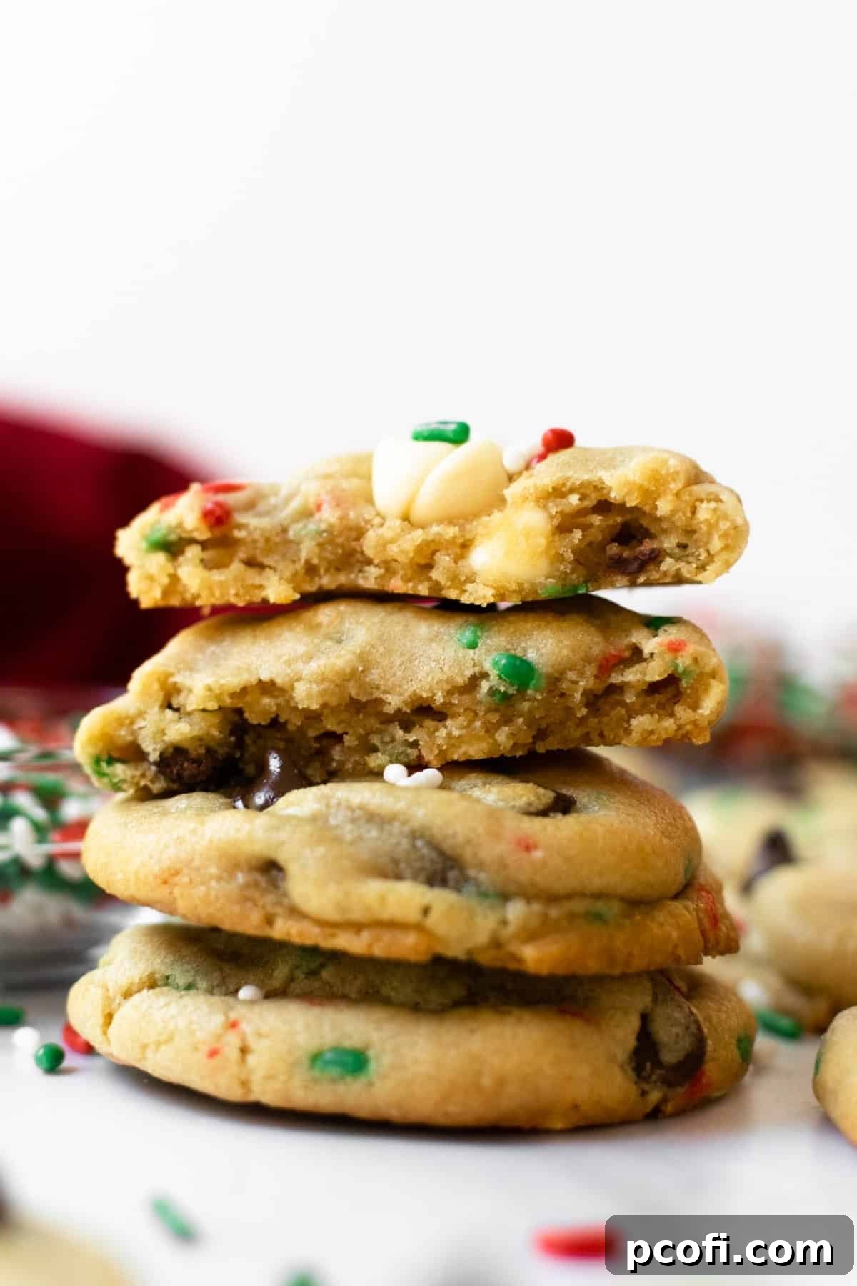 A vibrant stack of freshly baked cake batter cookies, generously decorated with festive red and green sprinkles, ready for holiday enjoyment.