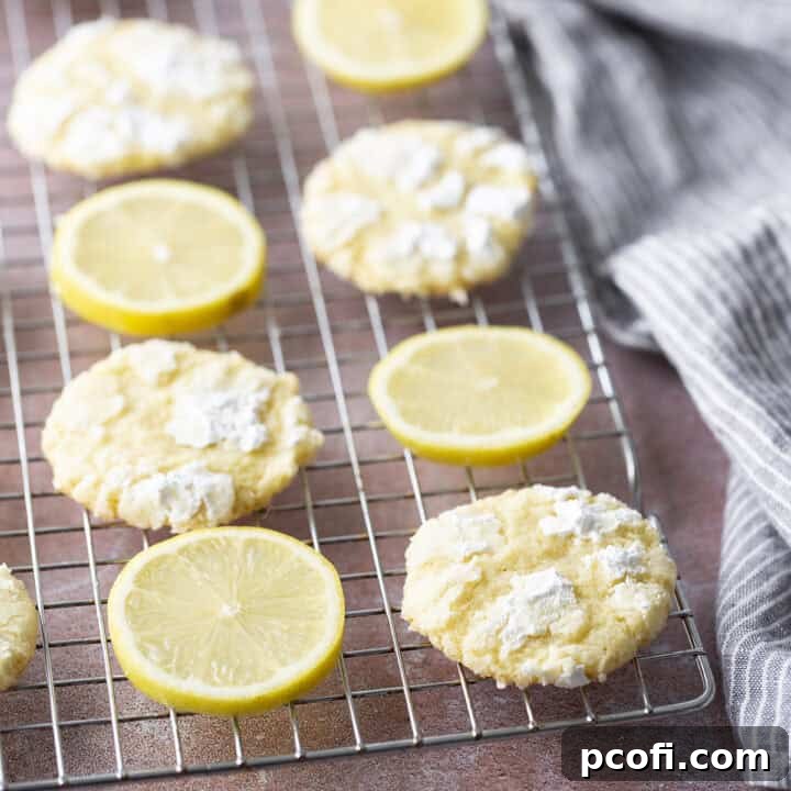 Lemon crinkle cookies on a wire cooling rack, beautifully powdered with sugar.