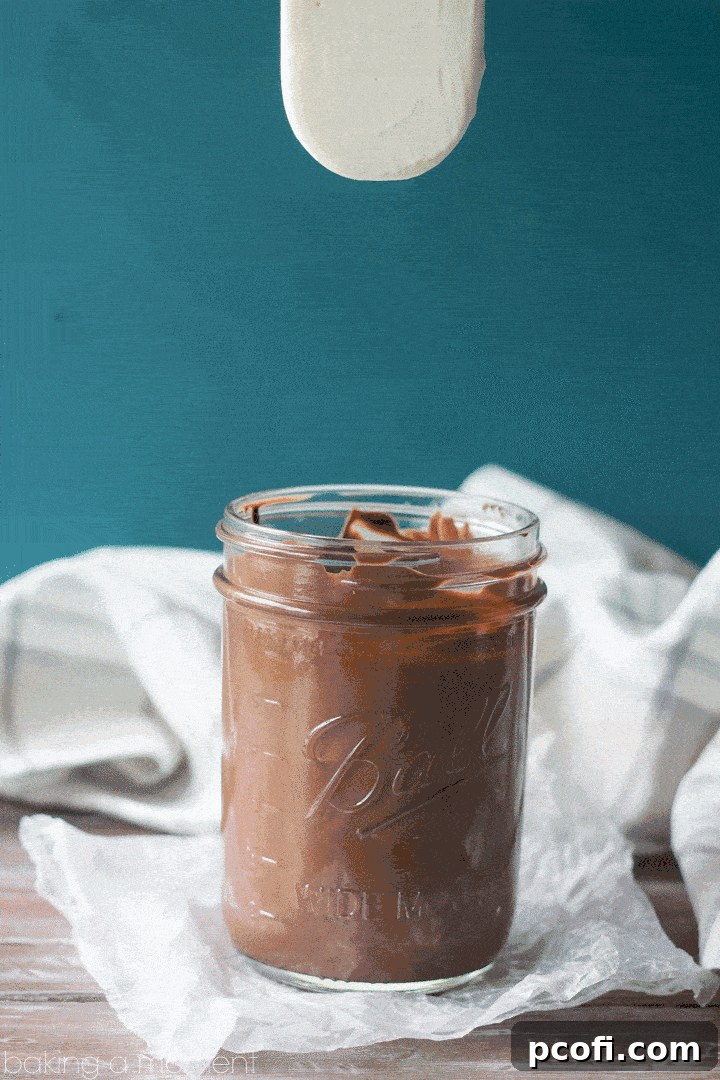 Hand holding a perfectly crafted Toffee Almond Ice Cream Pop with chocolate shell and generous toppings