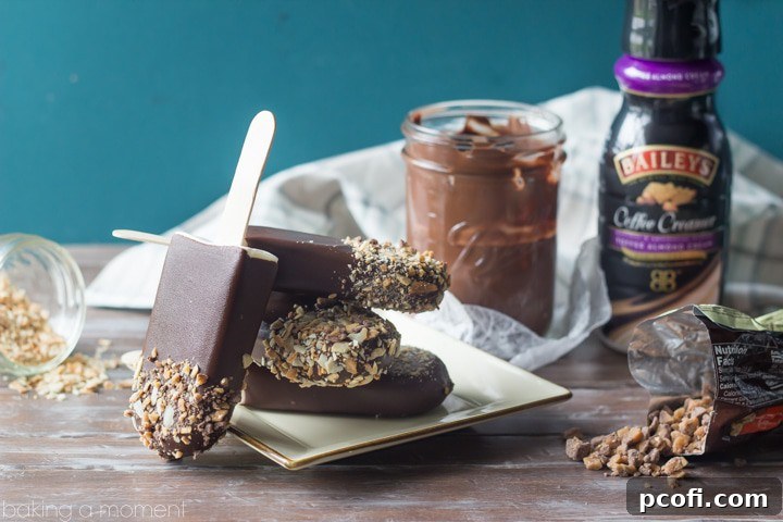 Toffee Almond No-Churn Ice Cream Pops, garnished with chocolate, almonds, and toffee bits, presented on a cooling rack