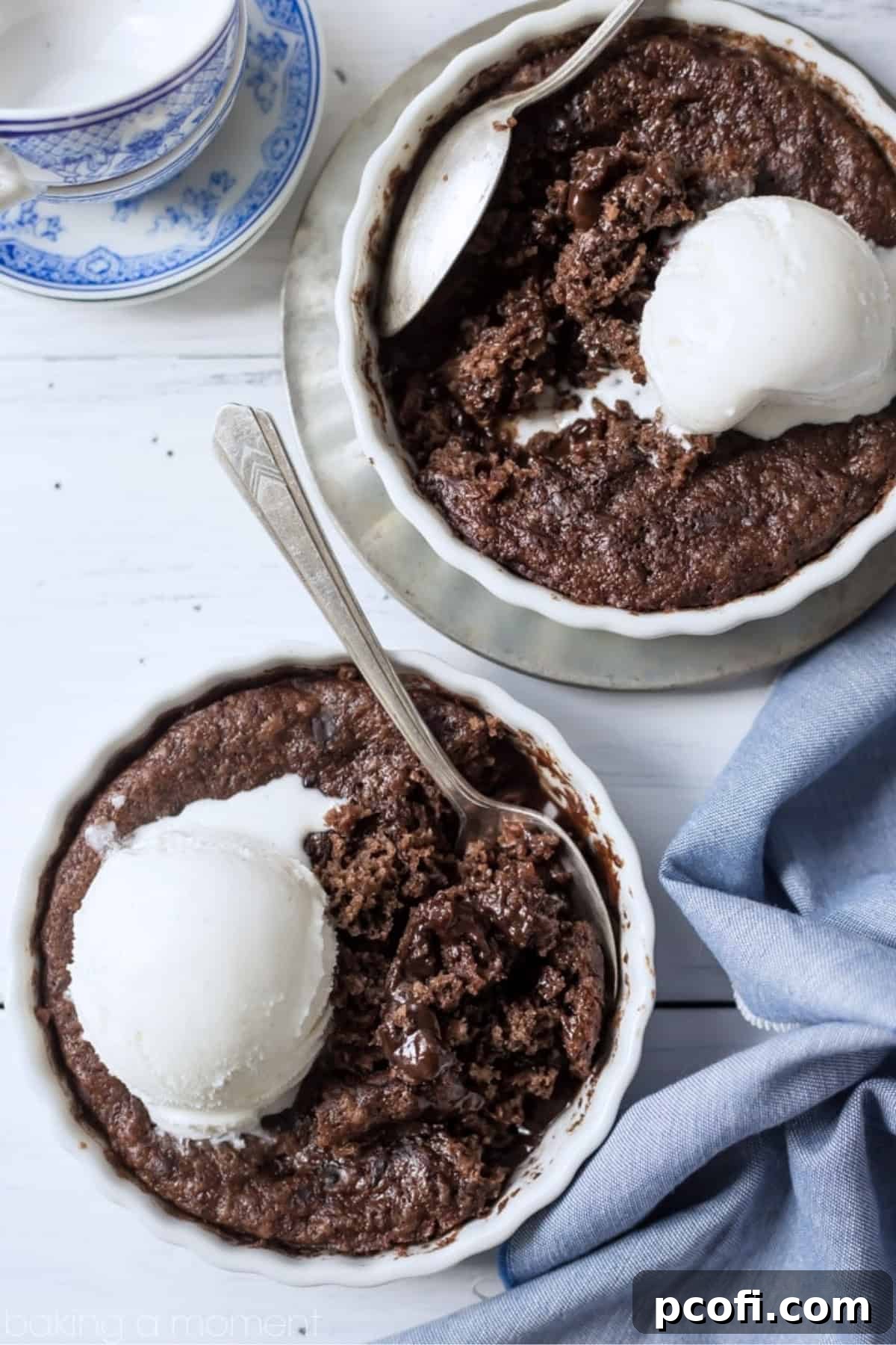 two bowls of brownie pudding cake topped with vanilla ice cream.