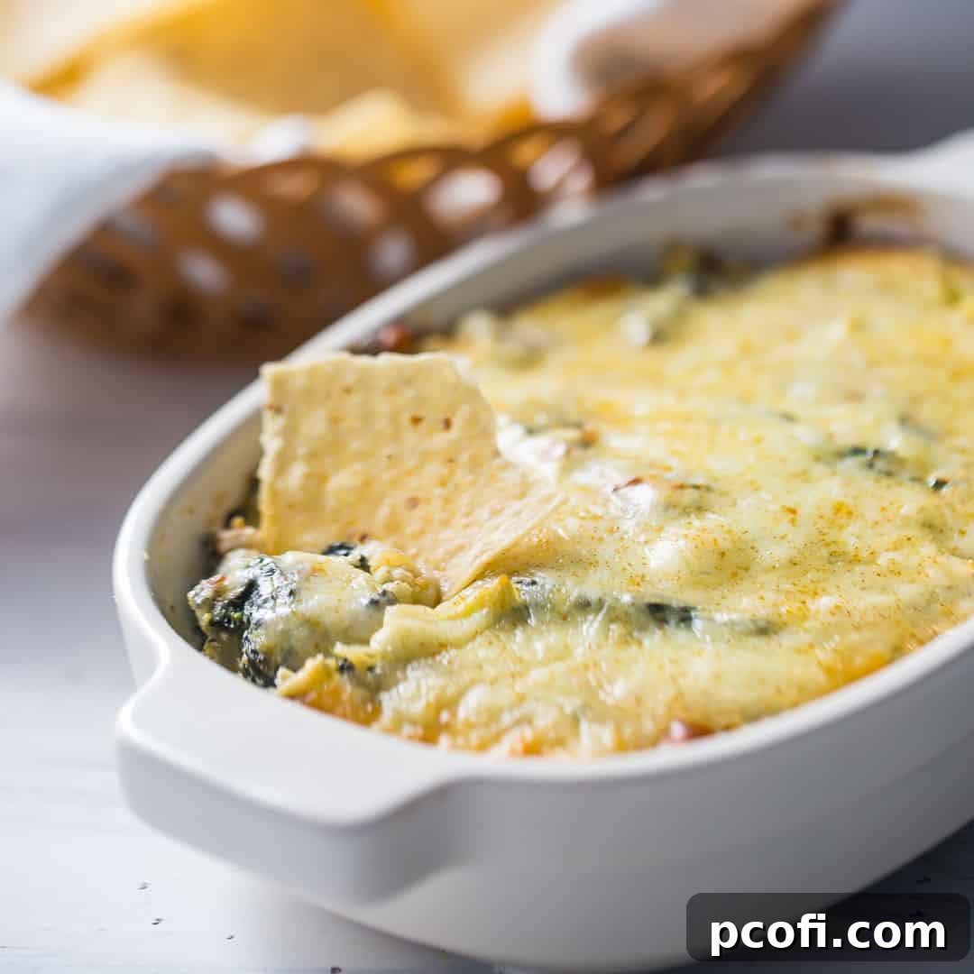 A hot, cheesy Spinach Artichoke Dip, garnished with fresh herbs, bubbling invitingly in a ceramic dish.
