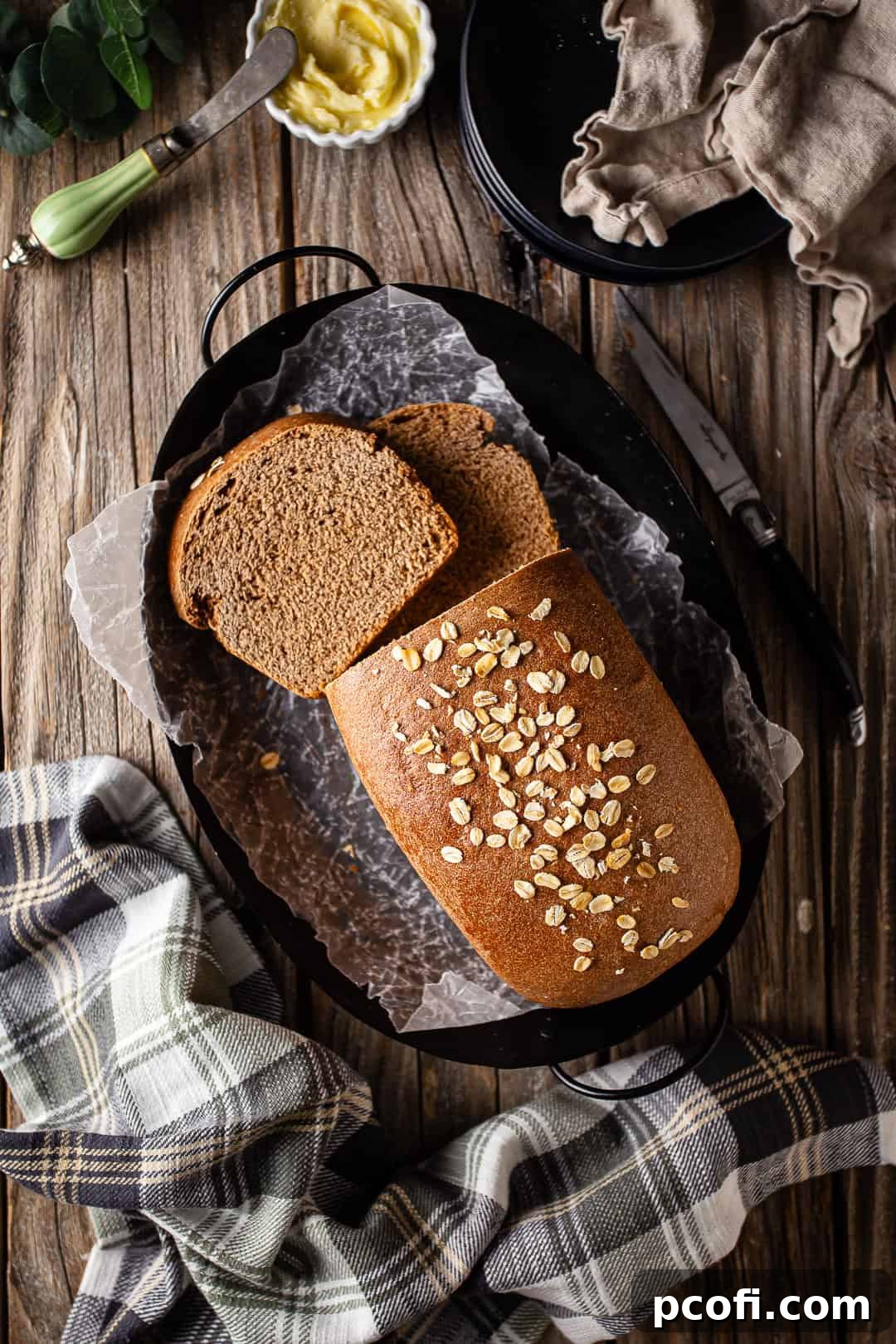 Overhead image of a loaf of Outback bread on a black platter, ready to be sliced and served.
