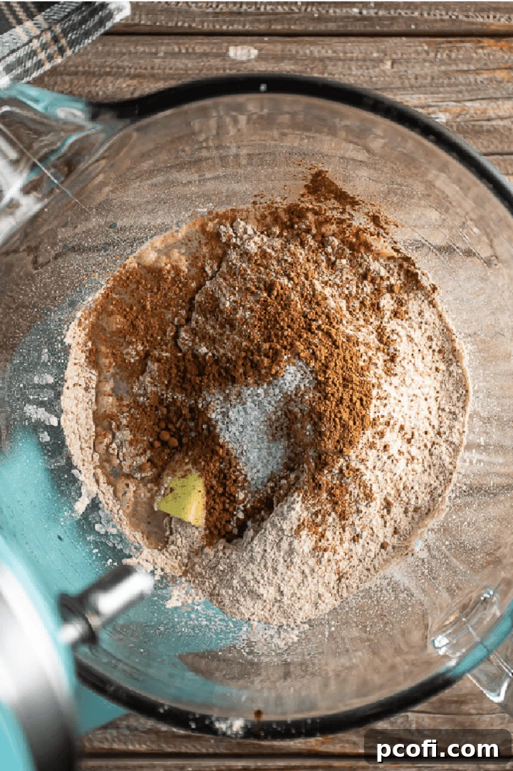 Adding soft butter, whole wheat flour, cocoa powder, and salt to the yeast mixture to make bread dough.