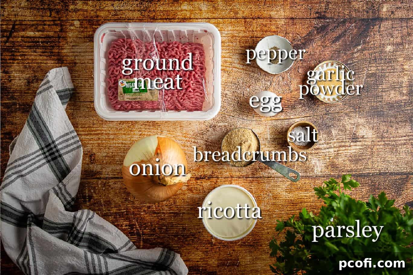 A selection of fresh ingredients laid out on a cutting board, including ground meat, ricotta cheese, onion, and herbs, ready for making meatballs.