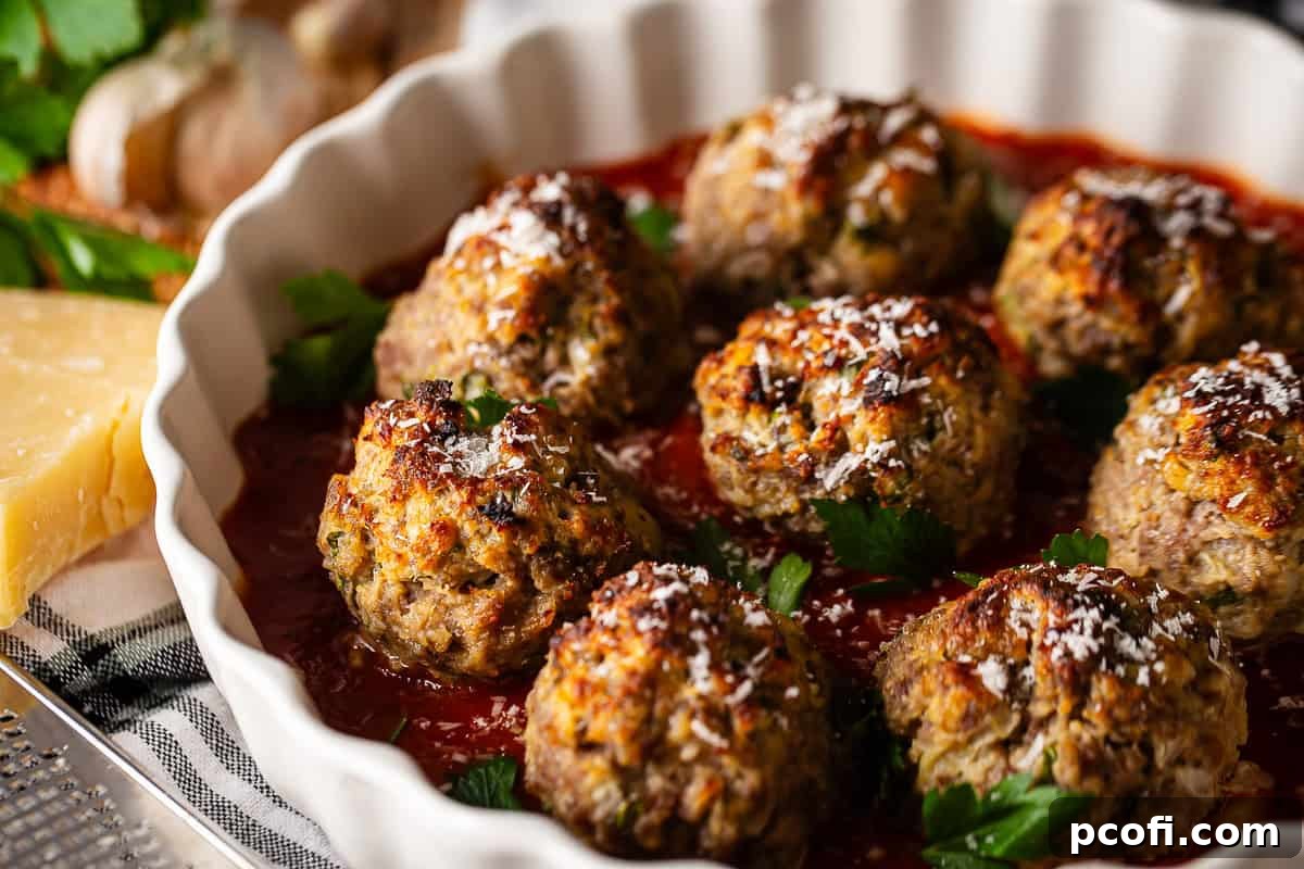 A large platter of cooked, tender meatballs, garnished with fresh parsley and ready to be served.