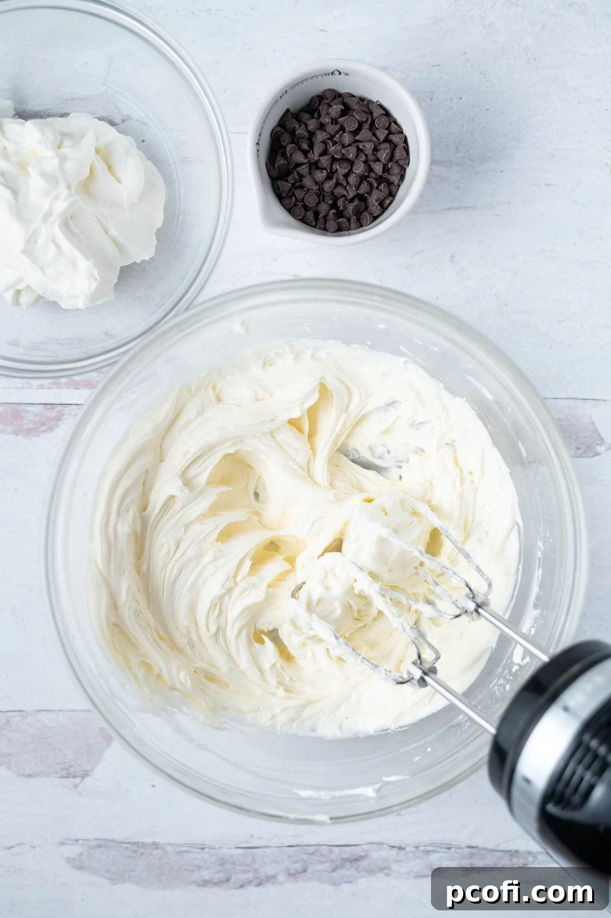 mascarpone, powdered sugar and vanilla mixed together in a bowl with a hand mixer