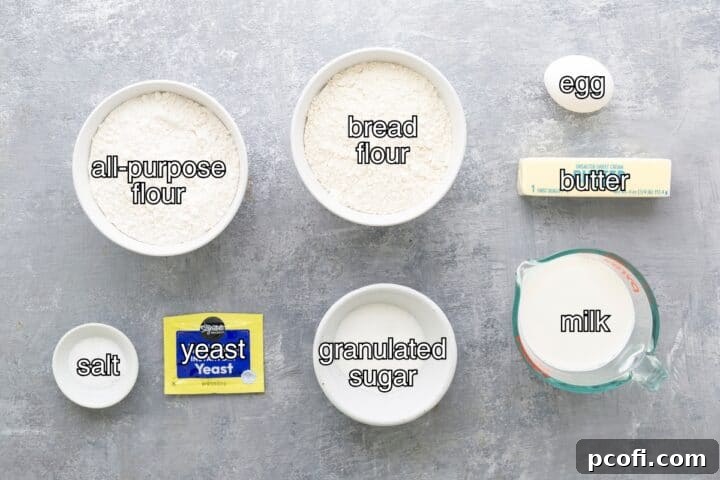 Fresh ingredients laid out for making milk bread: sugar, salt, yeast, flours, milk, butter, and an egg.