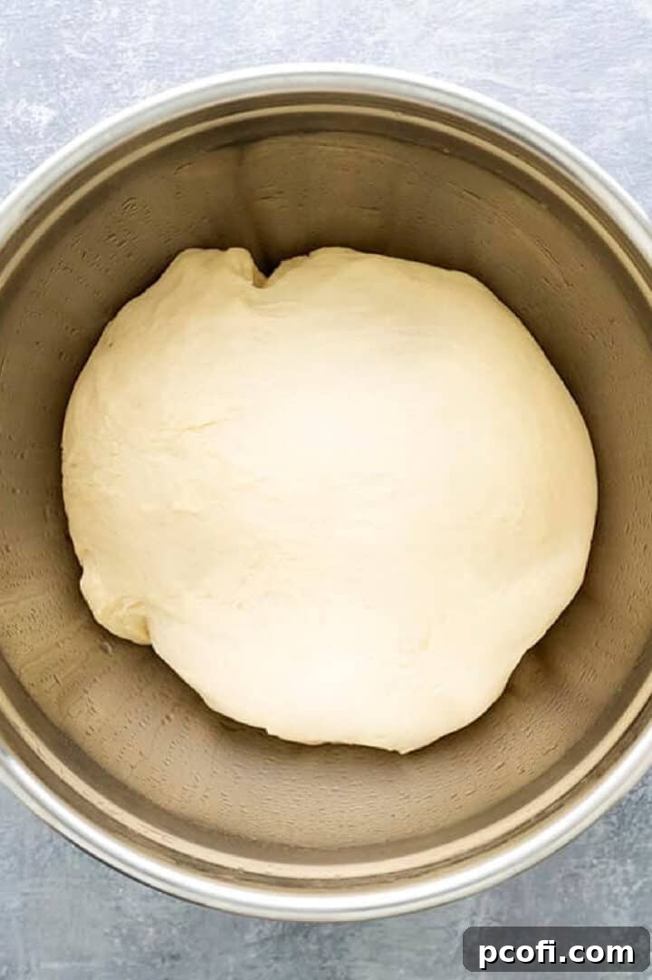 Milk bread dough in an oiled bowl, covered and risen to double its original size.