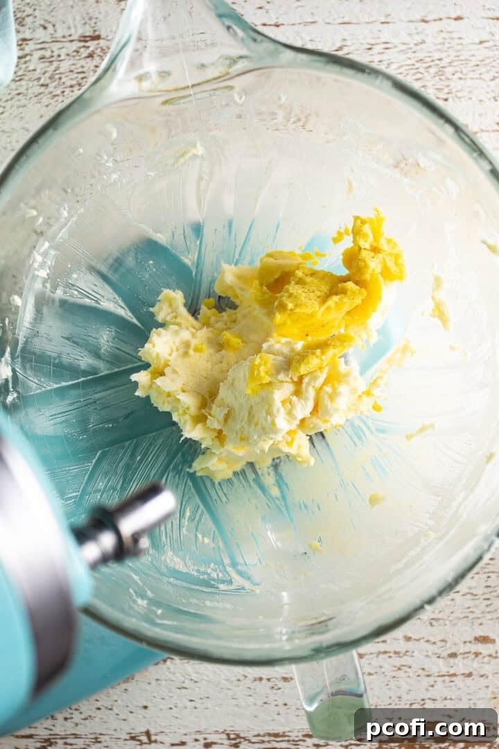 Chilled pastry cream being added spoonful by spoonful to whipped butter.