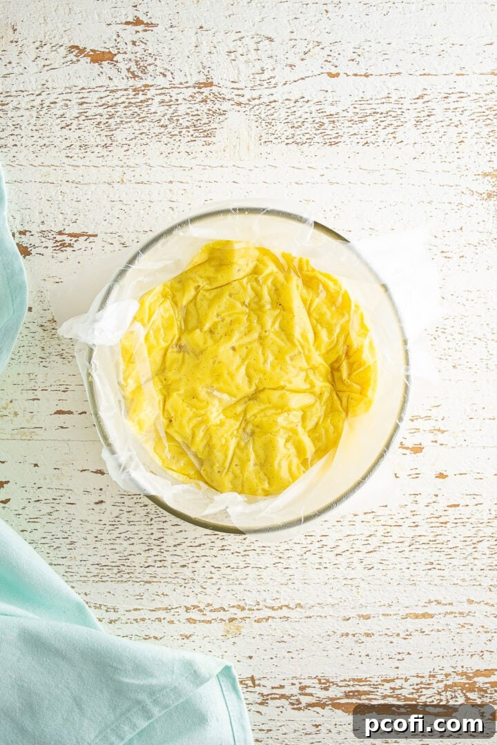 Plastic wrap pressed directly onto the surface of the pastry cream.