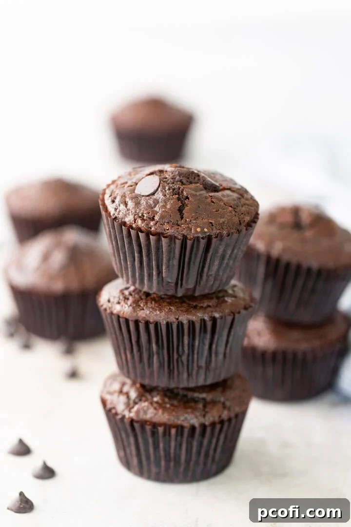 Freshly baked, stacked chocolate muffins with chocolate chips visible, ready to be enjoyed as a quick breakfast or sweet treat.