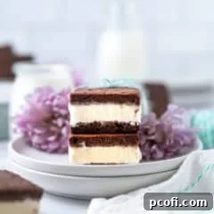 A stack of delightful homemade ice cream sandwiches on a plate, with a subtle background of flowers and a glass of milk, inviting you to enjoy this frozen treat.