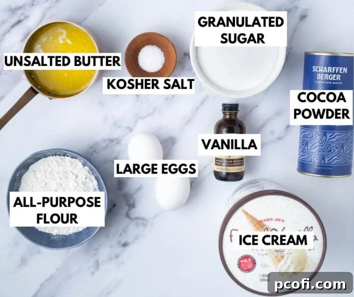A flat lay photograph showcasing all the ingredients required for making homemade ice cream sandwiches: sticks of butter, a bowl of granulated sugar, a measuring spoon with kosher salt, two large eggs, a bottle of vanilla extract, a bowl of all-purpose flour, a bowl of unsweetened cocoa powder, and a pint of vanilla ice cream, all neatly arranged.