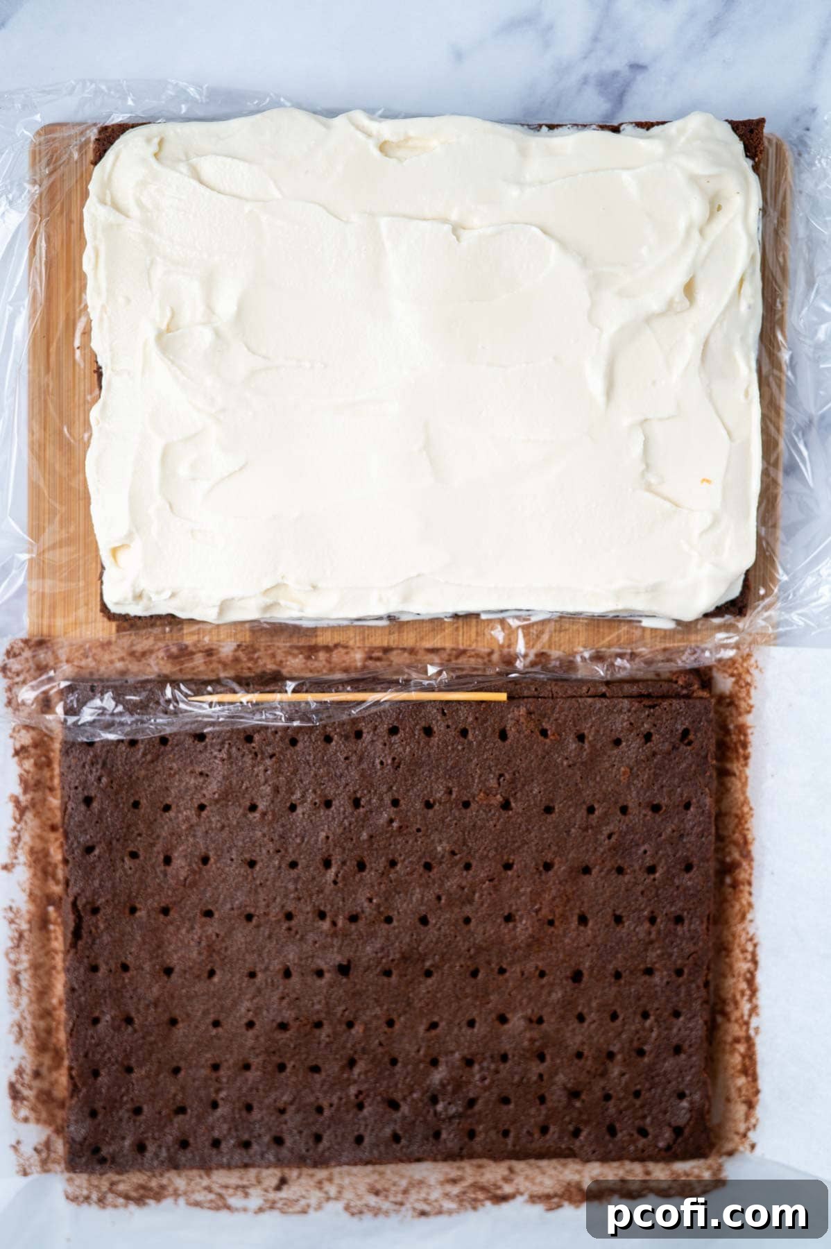 Step 6: Softened vanilla ice cream spread evenly on one half of the brownie cookie layer, with the second cookie layer (with holes) placed nearby, ready for assembly.