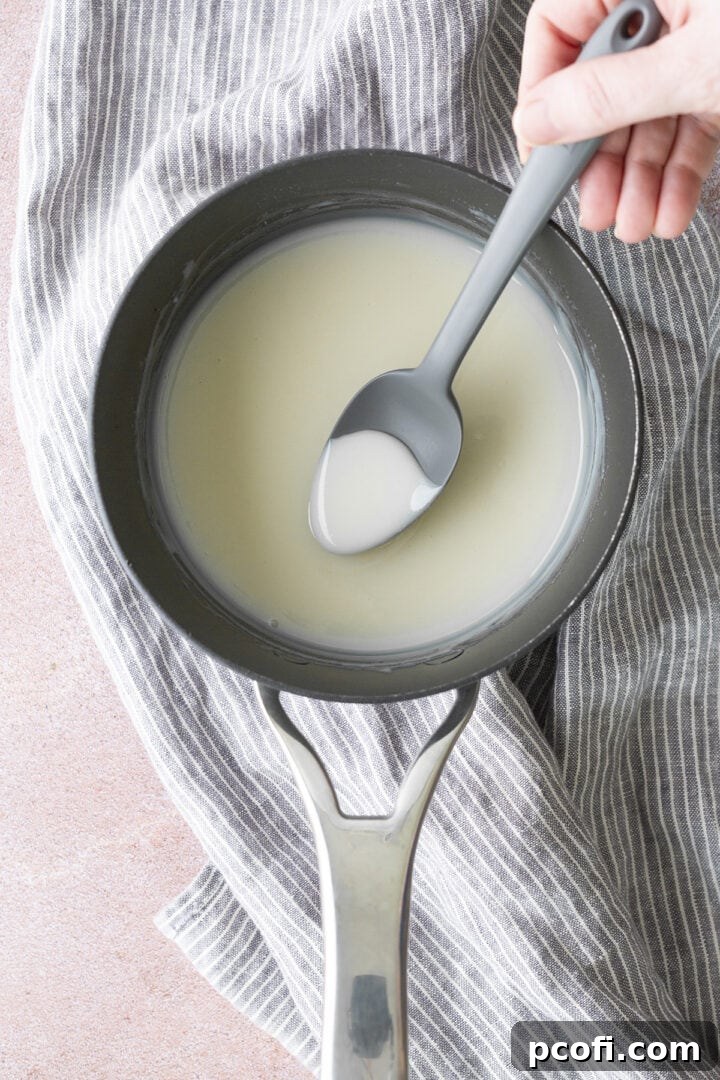 Ingredients thickened in a saucepan shown with a spoon