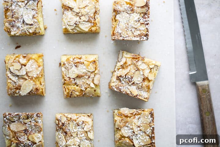 A close-up of a cut almond blondie showing the layers of blondie base and frangipane