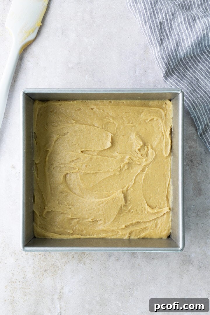 Blondie batter spread evenly into an 8x8 inch baking pan