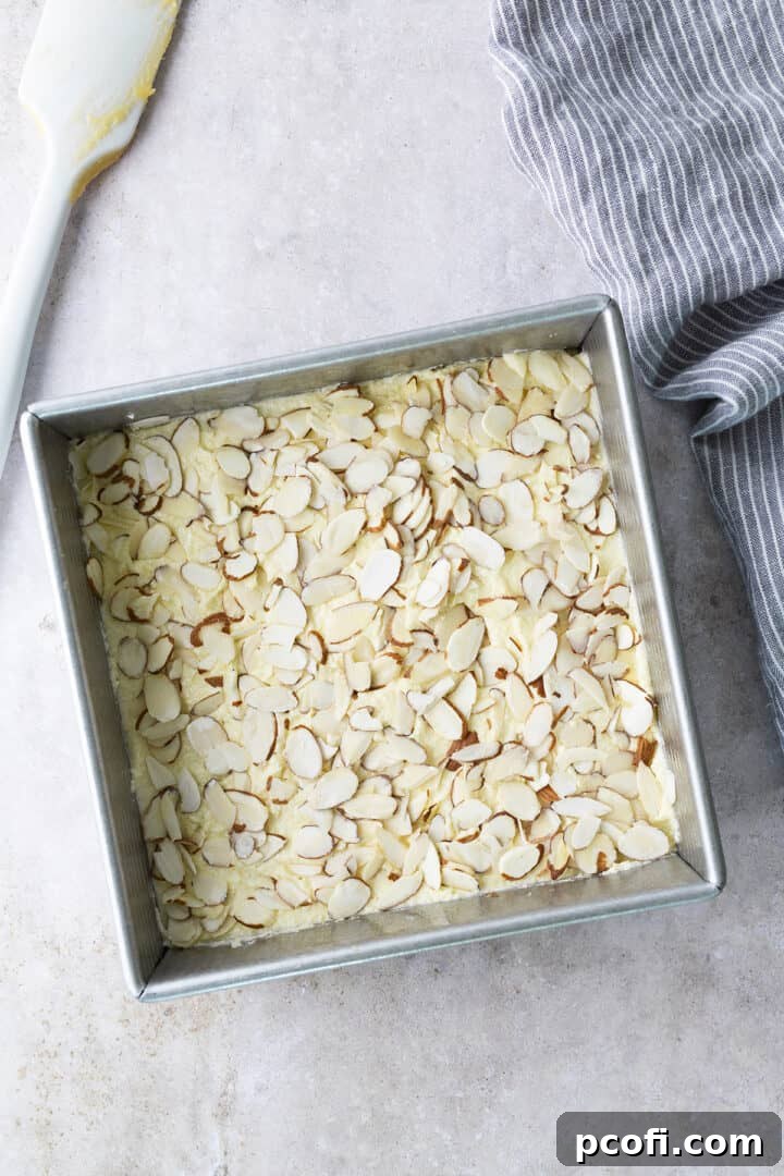 Sliced almonds sprinkled on top of the frangipane layer