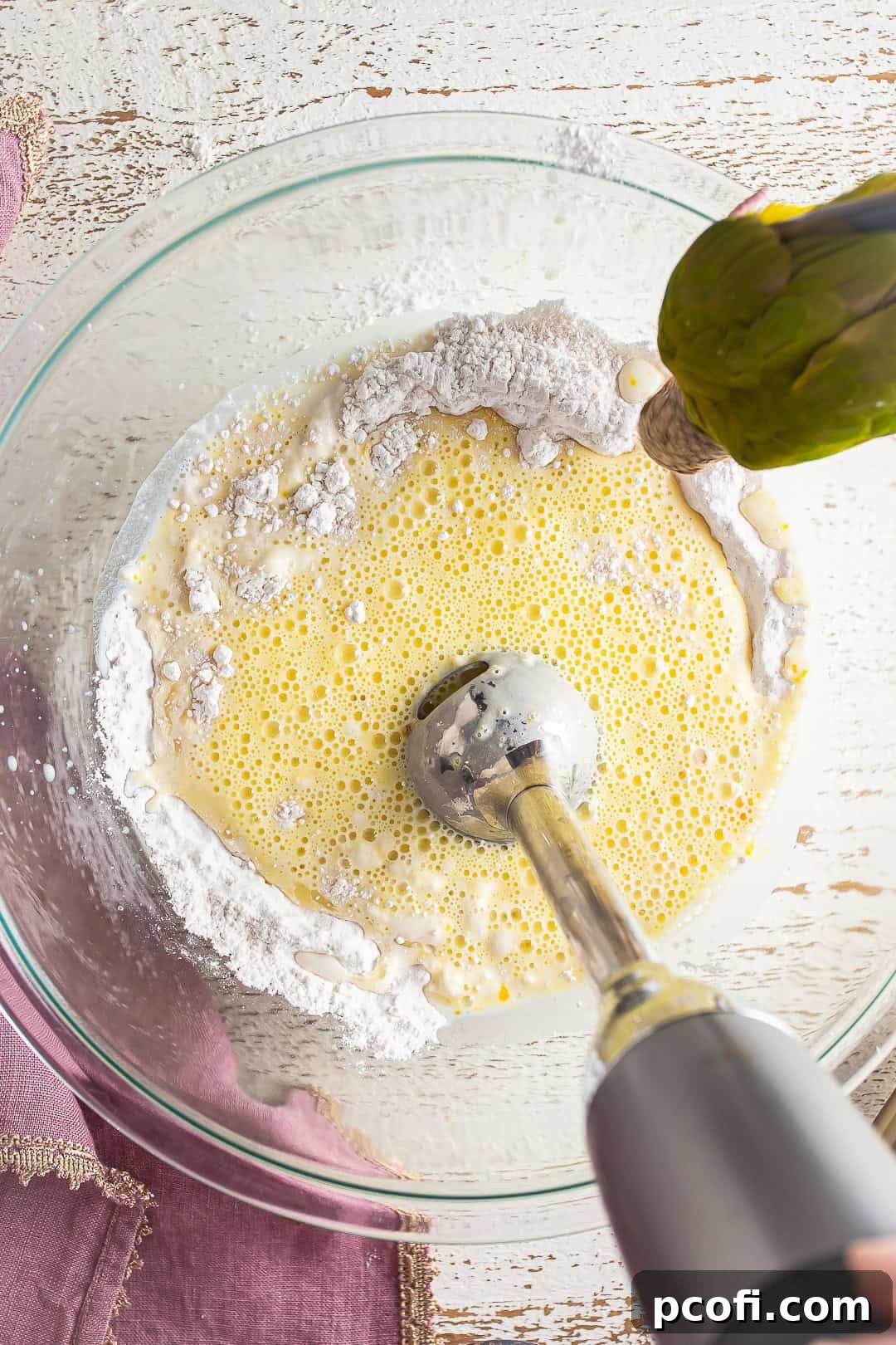 Blending liquids into dry ingredients with a hand blender.