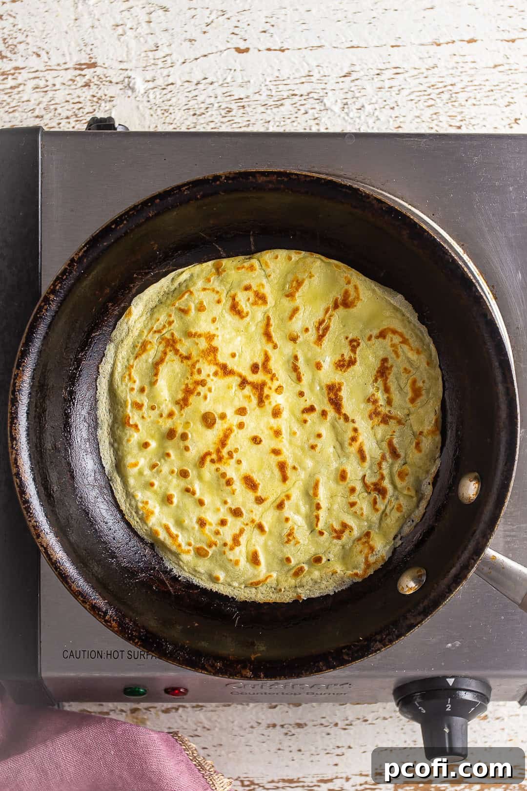 Flipping crepe to cook it on the other side.