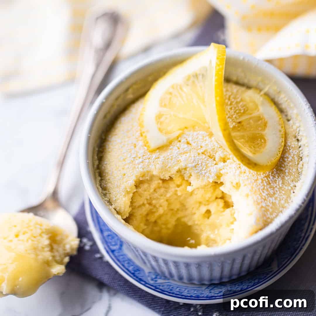 Lemon pudding cake in a ramekin with a lemon twist on top.