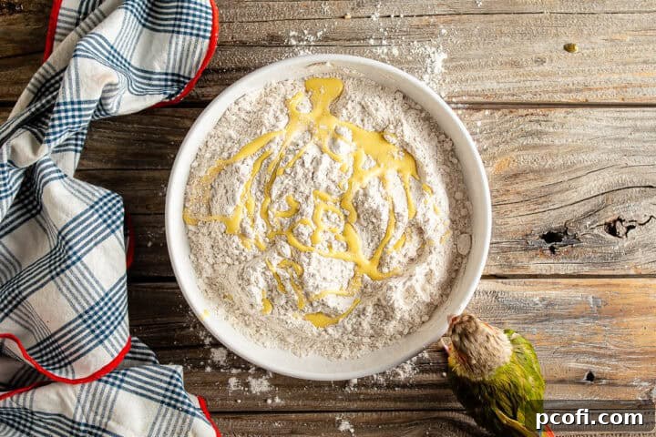 The ingenious step of drizzling wet batter into the seasoned flour, creating a unique crumbly texture for an extra-crunchy breaded coating on crispy chicken tenders.