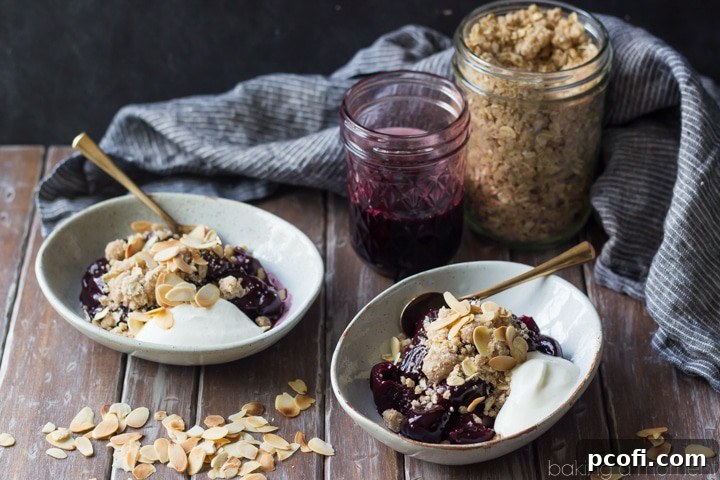 A wider shot showcasing a bowl of no-bake cherry crumble alongside a small dish of fresh cherries, emphasizing the natural ingredients.
