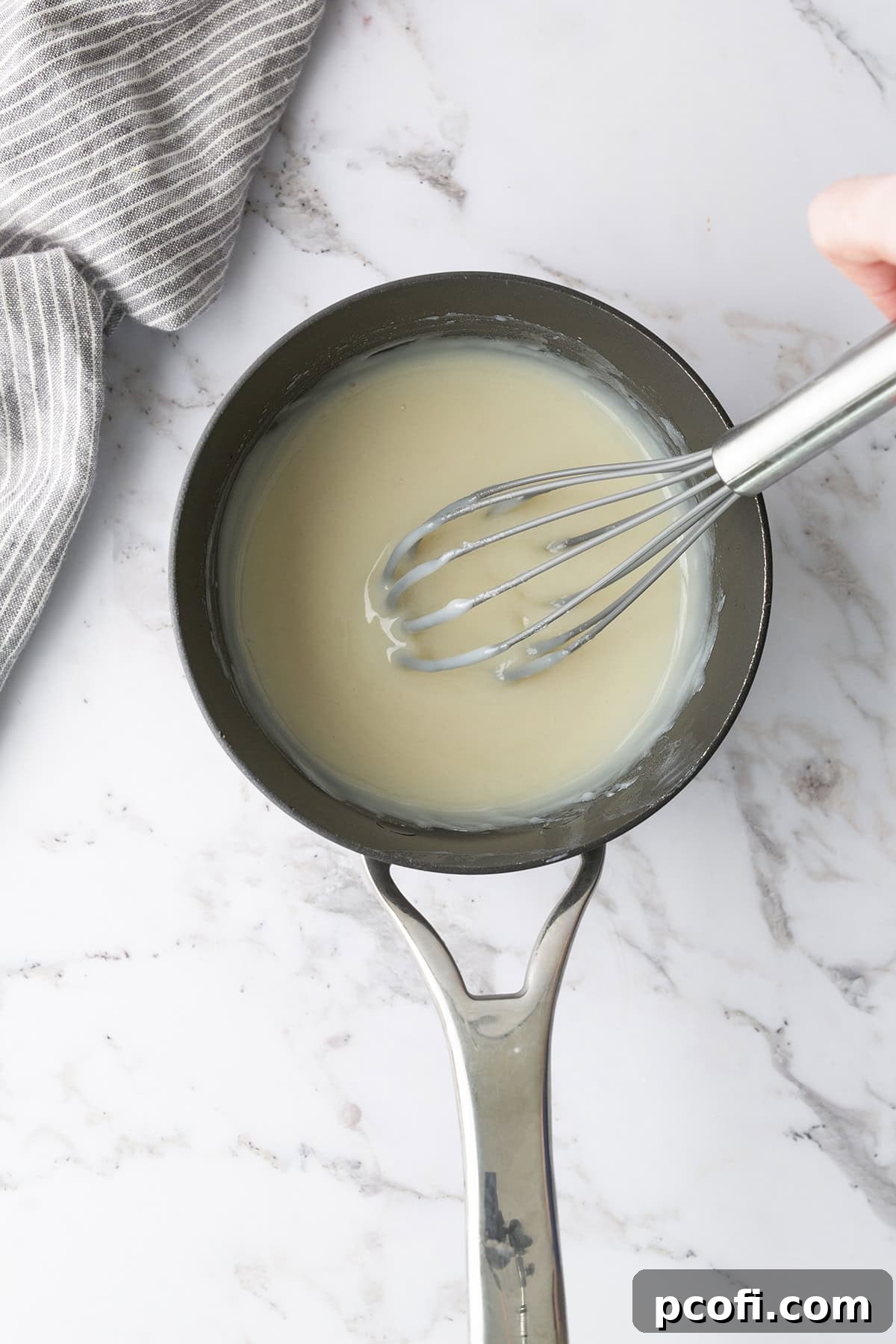 The thickened milk, flour, and sugar mixture, resembling a smooth pudding, in a saucepan.