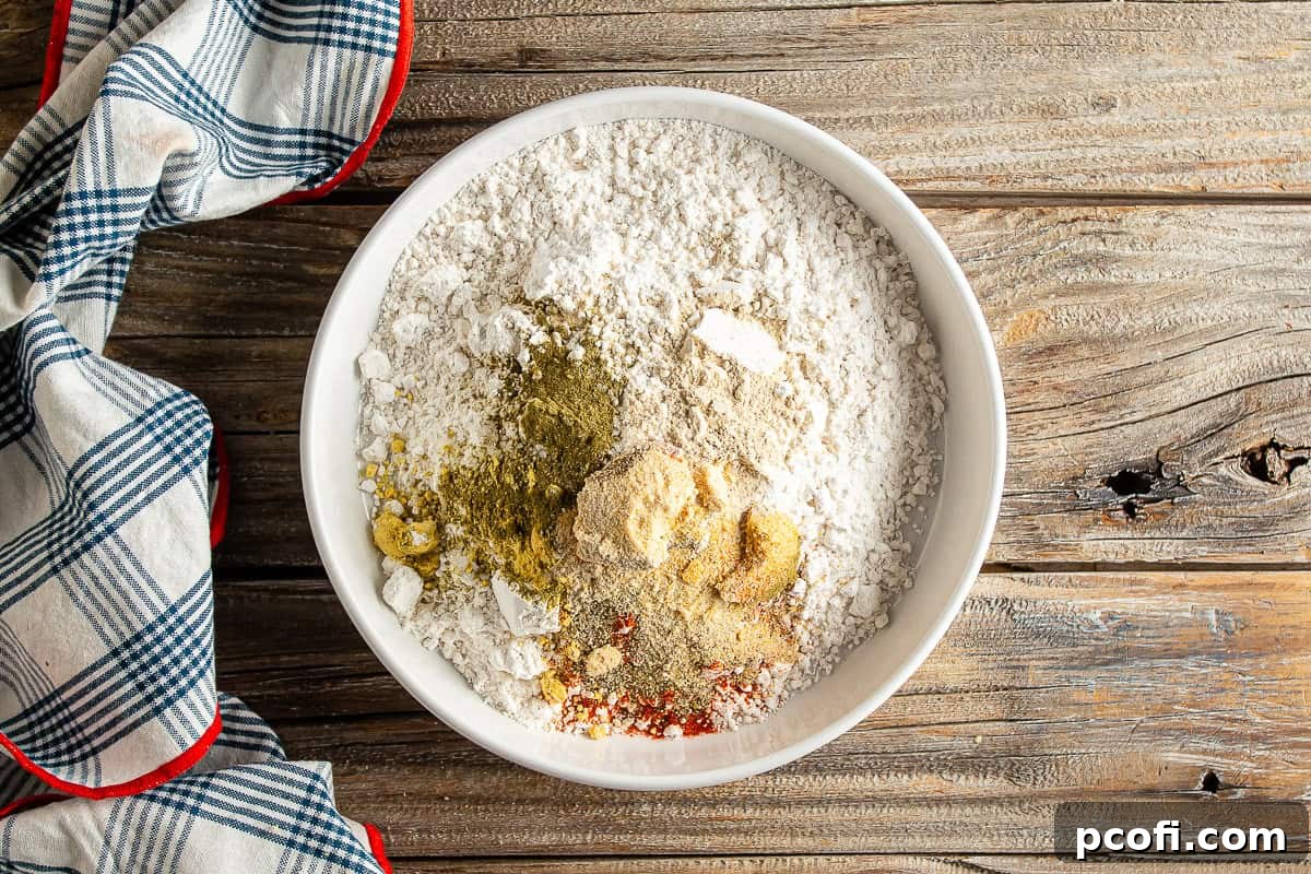 All the dry ingredients for breading chicken tenders, including various spices and flour.