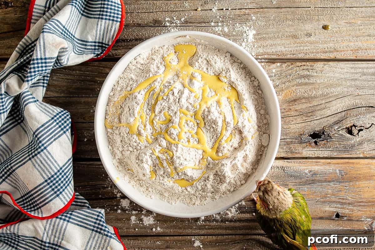 Drizzling small amounts of wet batter into seasoned flour to create craggy, crunchy bits for a crispy chicken coating.