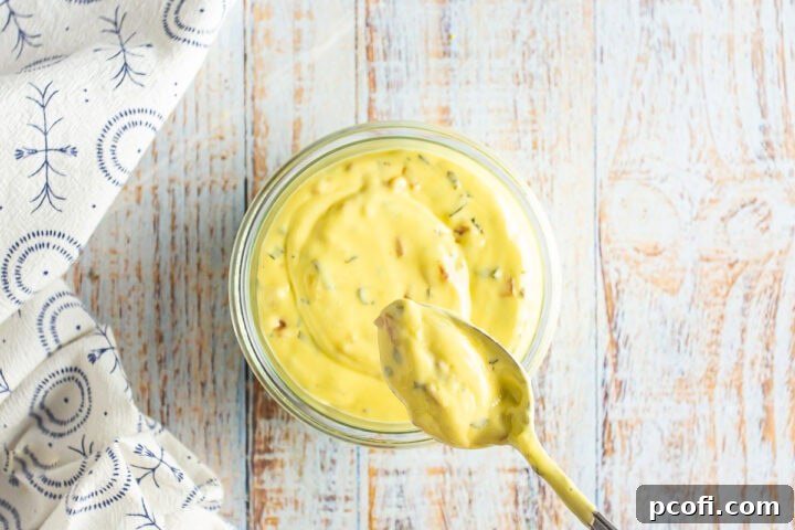 Homemade Bearnaise Sauce in a glass dish with a spoon.