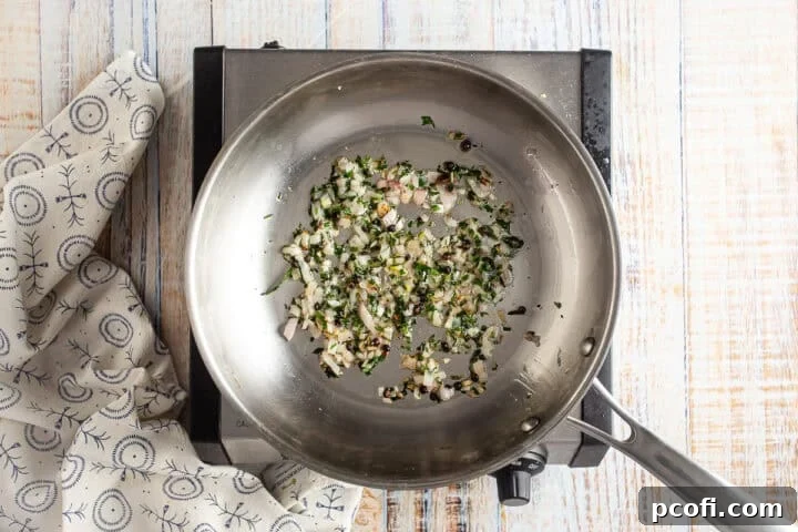 A pan with onions, peppers and herbs in it.