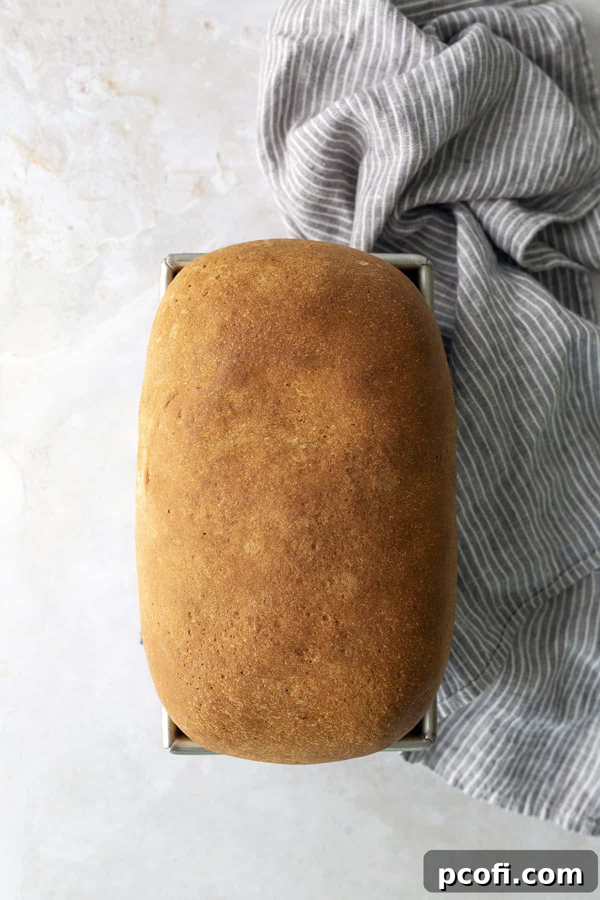 A perfectly baked loaf of Homemade Potato Bread, golden brown and glistening, cooling on a wire rack.