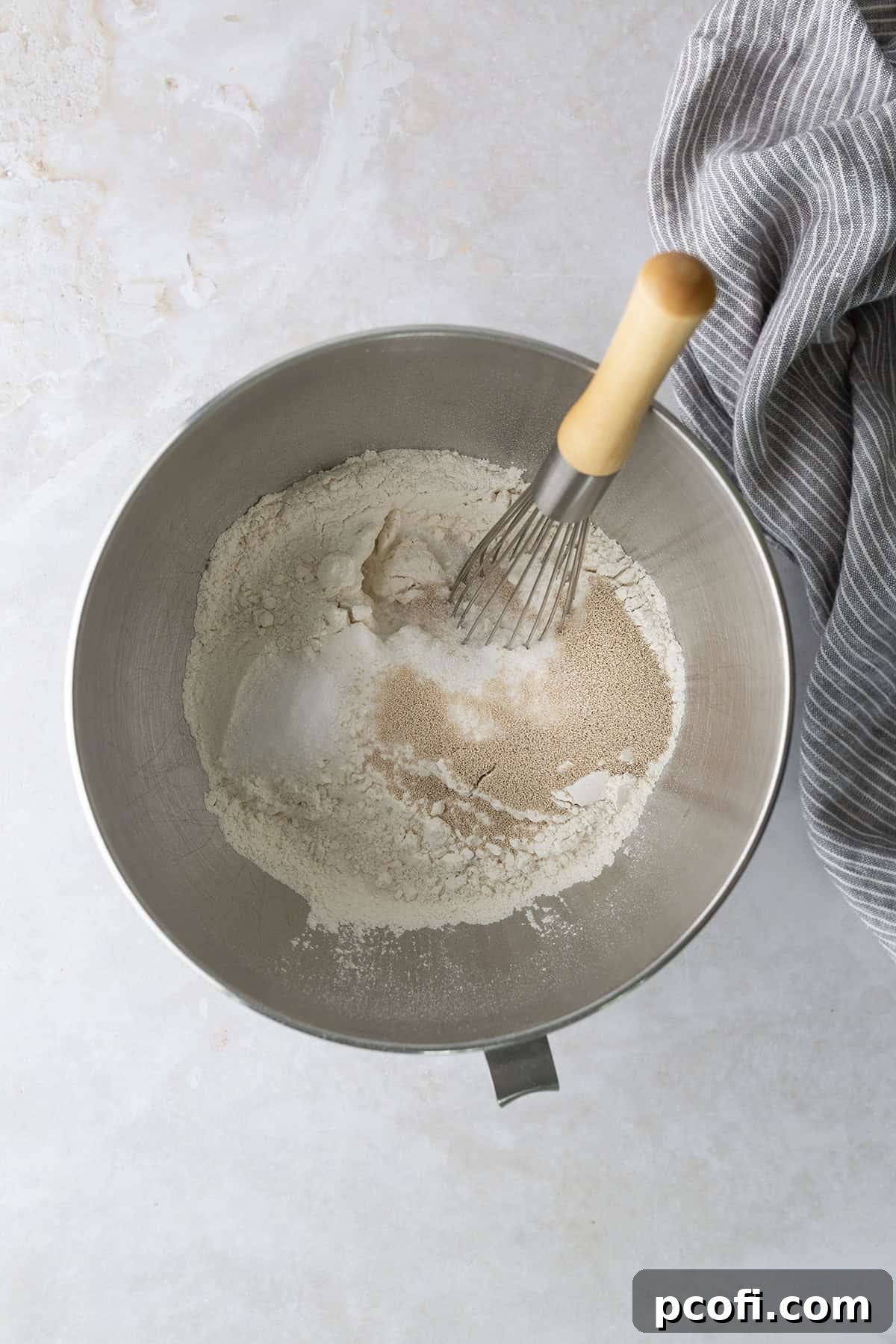 Dry ingredients for potato bread, including flour, sugar, yeast, and salt, whisked together in the bowl of a stand mixer.