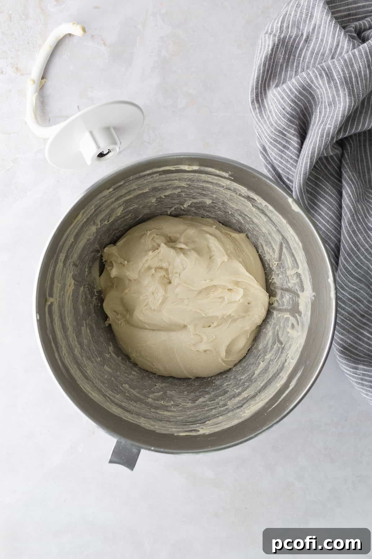 Potato bread dough, fully mixed and kneaded, forming a soft ball inside a stand mixer bowl.
