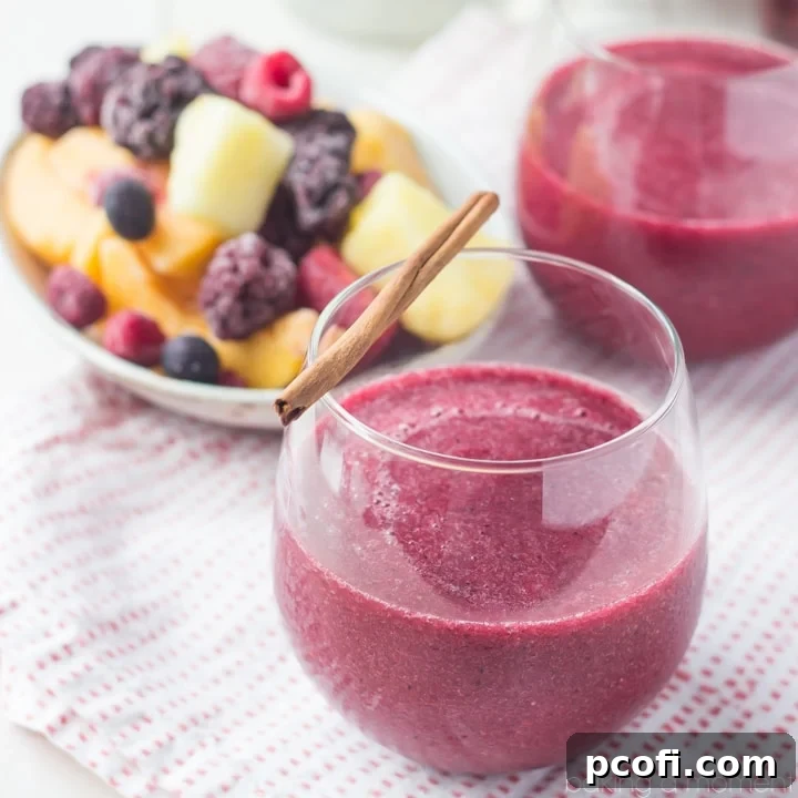 Vibrant red Frozen Sangria Slushie in a wine glass with mixed fruit garnish, perfect for summer.