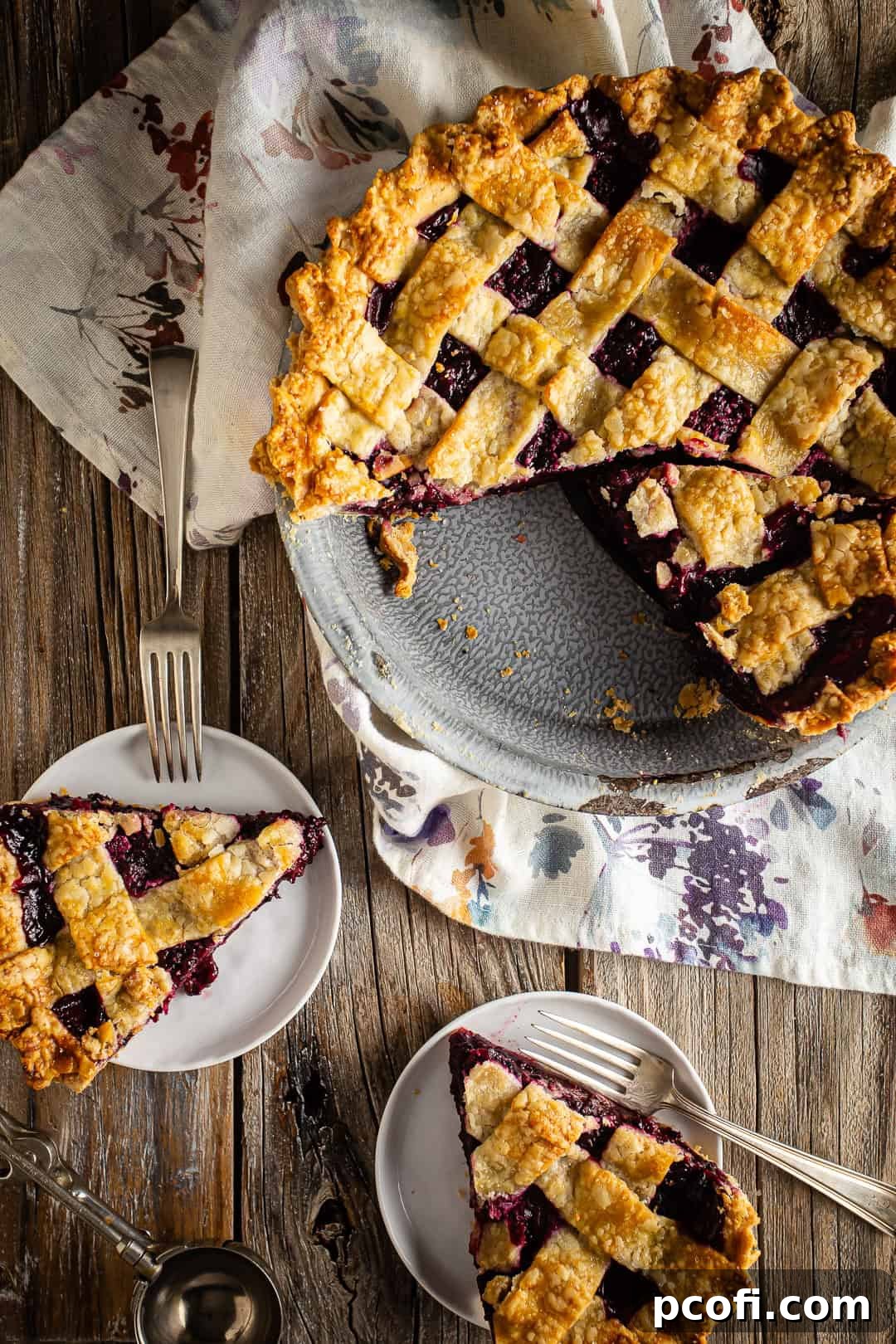 Blackberry Pie with a lattice crust pictured with a piece removed to a serving plate.