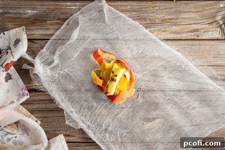 Apple cores and peels with lemon peel and seeds in cheesecloth.