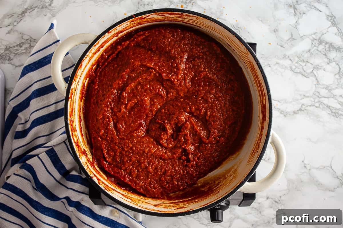 Cooked sauce for Tomato Pie pizza after being cooked down, showing a thick, dark red sauce.